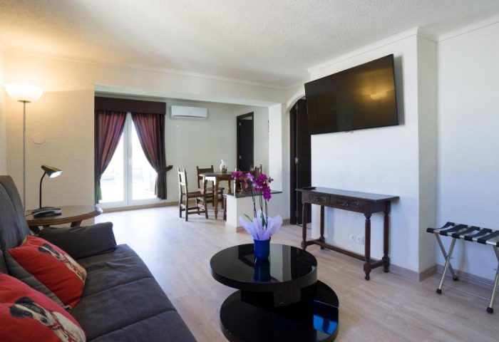 El Pozo gay-friendly hotel room. Living area with sofa, TV, and table. Modern design, comfortable for gay travelers. #GayTravel #GayHotel