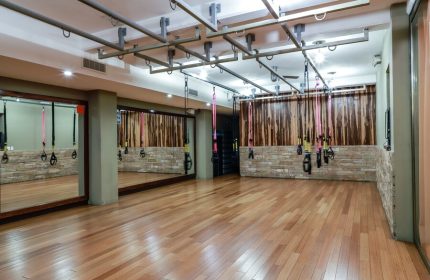 El Taj Oceanfront Condo Hotel's gym. Exercise room with wood floors, mirrors, and TRX suspension training equipment. Gay-friendly hotel.