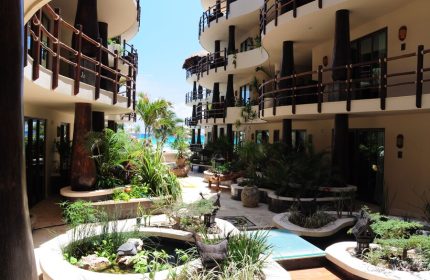El Taj Oceanfront Condo Hotel courtyard view. Gay-friendly beachside hotel with lush gardens, pools, and ocean views. Playa del Carmen travel.