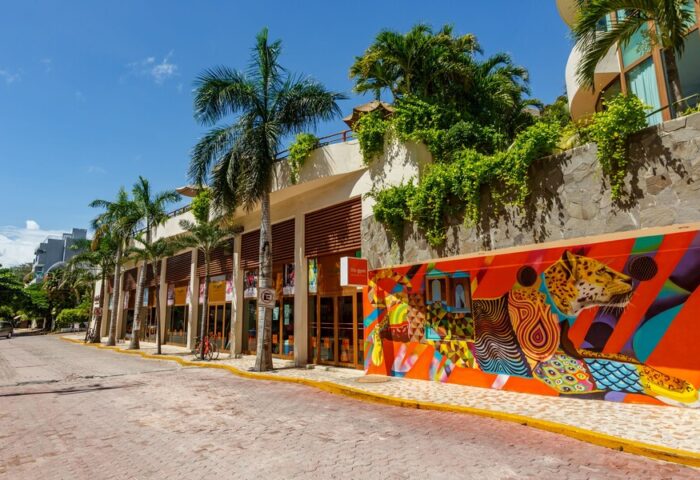 El Taj Oceanfront Condo Hotel street view. Gay-friendly hotel with colorful mural art. Beachside hotel with palm trees.