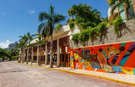 El Taj Oceanfront Condo Hotel street view. Gay-friendly hotel with colorful mural art. Beachside hotel with palm trees.