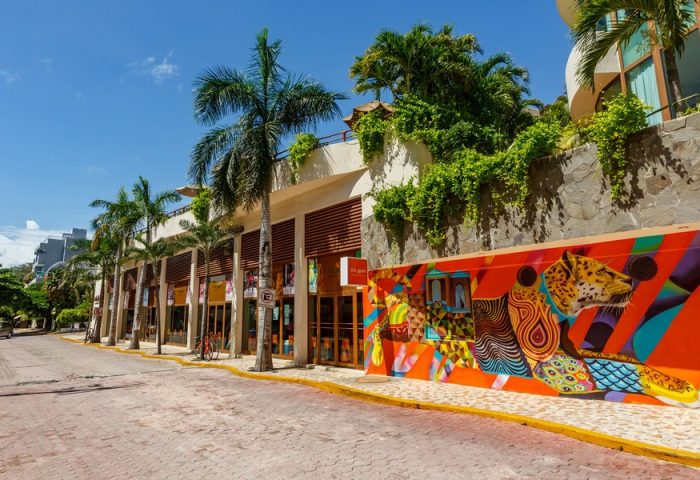 El Taj Oceanfront Condo Hotel street view. Gay-friendly hotel with colorful mural art. Beachside hotel with palm trees.