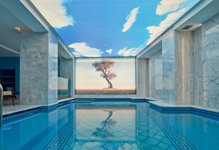 Electra Metropolis Hotel's indoor pool. A gay-friendly hotel with a blue tiled pool, marble walls, and a sky and tree mural. Relaxing gay travel.