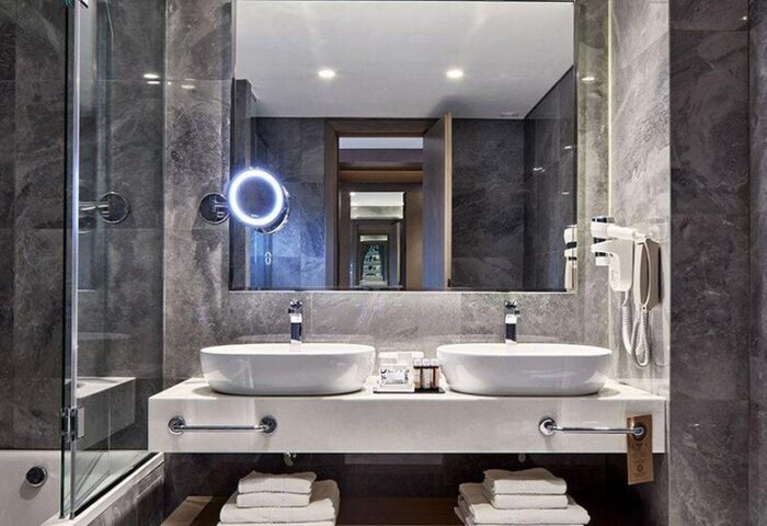 Electra Metropolis Hotel bathroom. Gay-friendly hotel room with double sinks, marble walls, and modern design. Luxury travel for gay men.