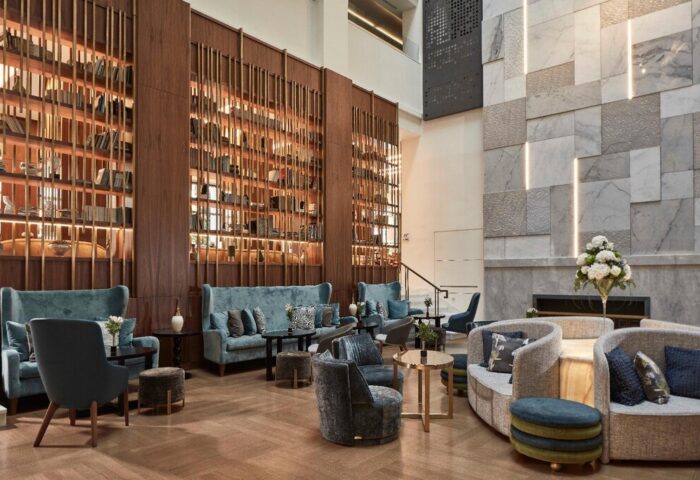 Electra Metropolis Hotel's lobby. Gay-friendly hotel with stylish seating, bookshelves, and marble walls. Upscale travel for gay men.