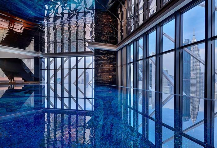 Element Kuala Lumpur gay-friendly hotel pool with city views. Modern design, blue mosaic tiles, and floor-to-ceiling windows.