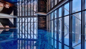 Element Kuala Lumpur gay-friendly hotel pool with city views. Modern design, blue mosaic tiles, and floor-to-ceiling windows.