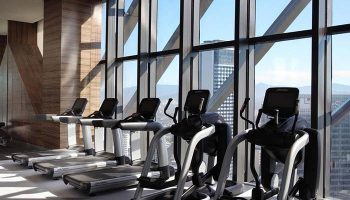 Element Kuala Lumpur gay-friendly hotel gym. Treadmills and elliptical machines face a large window with city views. Fitness for gay travelers.