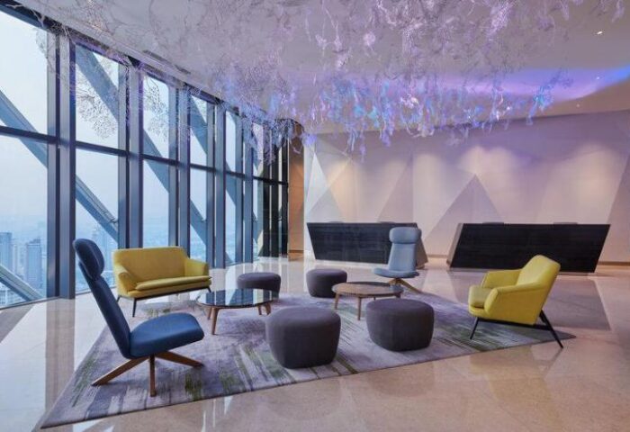 Element Kuala Lumpur, a gay-friendly hotel. Modern lobby with floor-to-ceiling windows, stylish seating, and unique lighting.