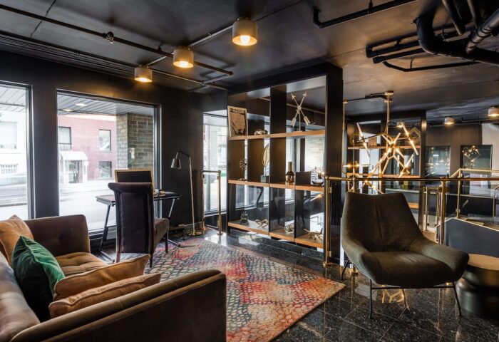 Empire Suites, a gay-friendly hotel. Modern lounge area with seating, desk, and shelving. Stylish interior design for gay travelers.