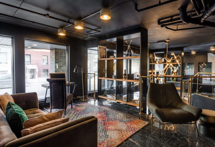 Empire Suites, a gay-friendly hotel. Modern lounge area with seating, desk, and shelving. Stylish interior design for gay travelers.