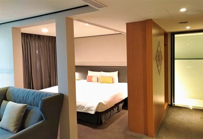 Energy Inn, a gay-friendly hotel: Interior view of a modern room with a bed, couch, and bathroom, designed for comfort and style.