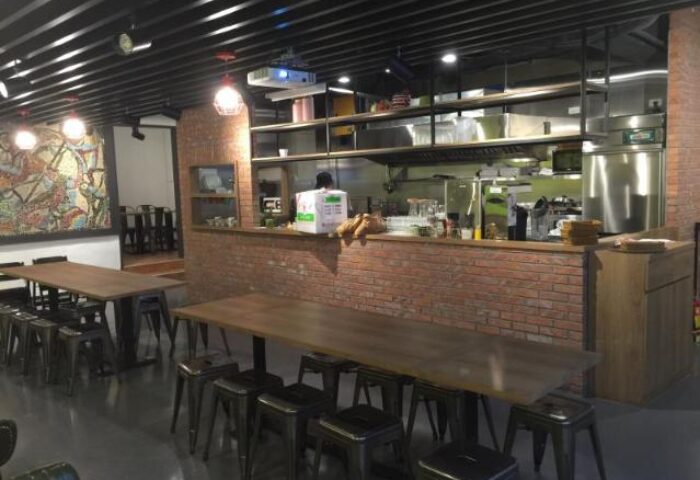 Energy Inn gay-friendly hotel restaurant. Interior view of tables and chairs. Brick bar counter and open kitchen. LGBT travel.