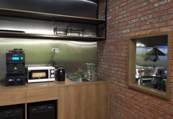 Energy Inn, a gay-friendly hotel: Kitchenette with microwave, sink, and brick wall. A comfortable space for gay travelers.