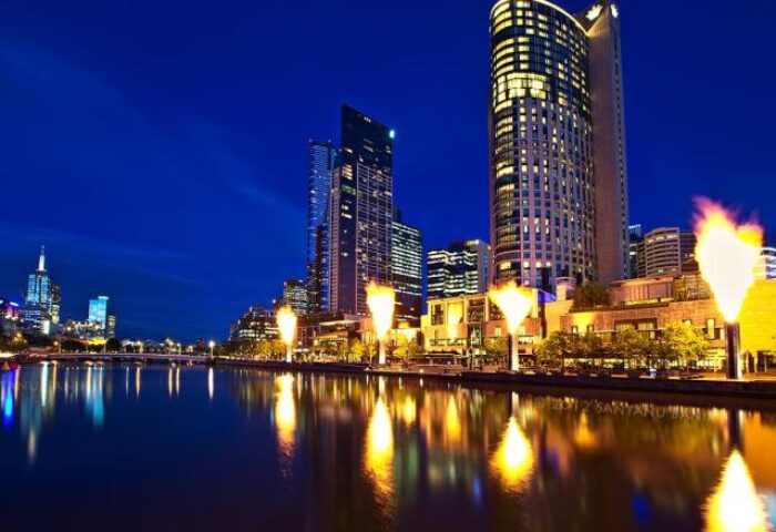 Essence Hotel Carlton, a gay-friendly hotel. Night view of Melbourne, Australia, with city lights reflecting on the river. Gay travel.