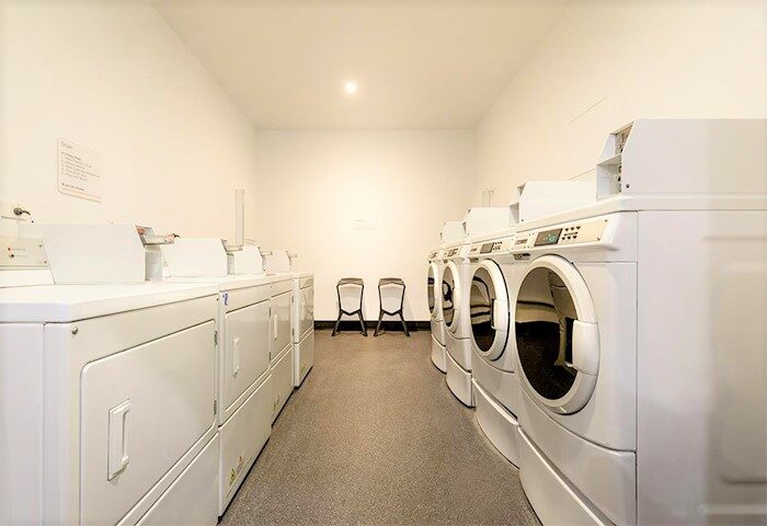 Essence Hotel Carlton laundry room. Gay-friendly hotel offers convenient washing machines for guests. Clean and bright space for easy laundry.