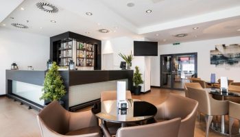 Eurostars Budapest Center gay-friendly hotel bar area. Modern design with tables, chairs, and a well-stocked bar. Ideal for gay travelers.