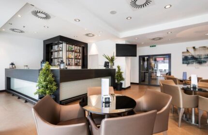 Eurostars Budapest Center gay-friendly hotel bar area. Modern design with tables, chairs, and a well-stocked bar. Ideal for gay travelers.
