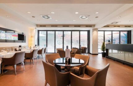 Eurostars Budapest Center gay-friendly hotel restaurant. Tables with white tablecloths and brown chairs. Relaxing space for hotel guests.