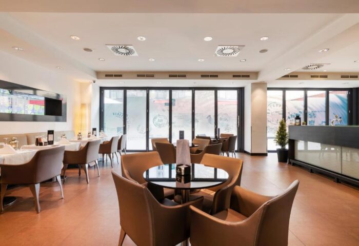 Eurostars Budapest Center gay-friendly hotel restaurant. Tables with white tablecloths and brown chairs. Relaxing space for hotel guests.
