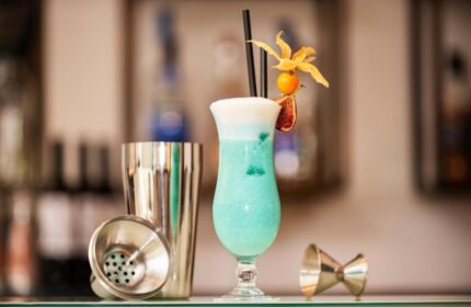 Cocktail at Eurostars Budapest Center, a gay-friendly hotel. Blue drink with garnish, shaker, and jigger. Ideal for gay travel in Budapest.