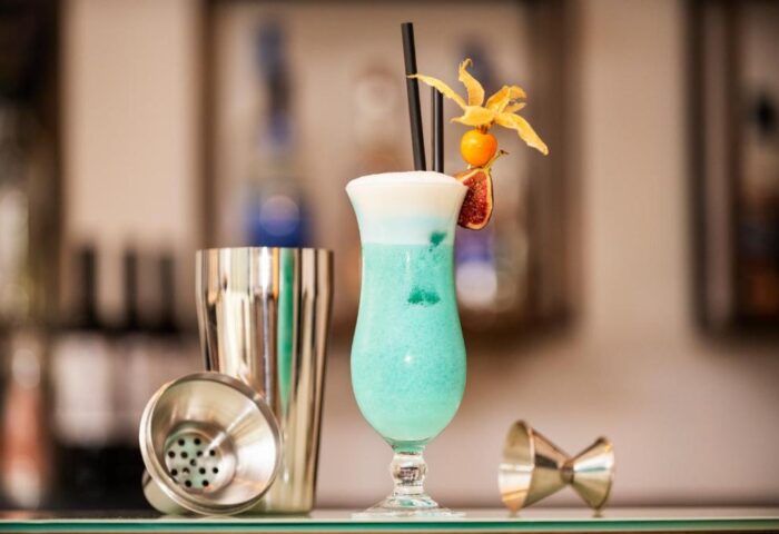 Cocktail at Eurostars Budapest Center, a gay-friendly hotel. Blue drink with garnish, shaker, and jigger. Ideal for gay travel in Budapest.