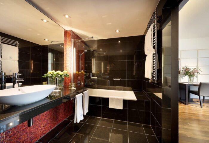 Eurostars Grand Central Hotel bathroom. Gay-friendly hotel featuring modern design, black tiles, a sleek sink, and a bathtub. Upscale amenities.