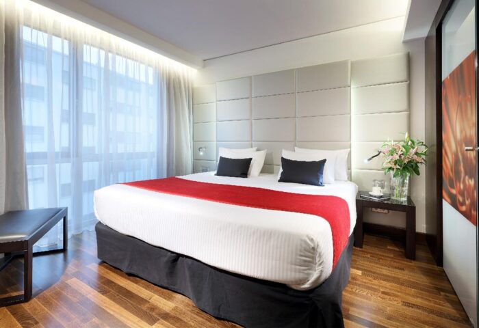 Eurostars Grand Central Hotel room. Gay-friendly hotel bedroom with king bed, red runner, and modern decor. Perfect for gay travel.