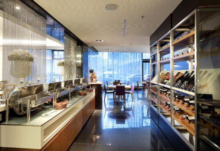 Eurostars Grand Central Hotel's restaurant. Gay-friendly hotel with buffet, dining tables, and wine rack. Modern interior design.