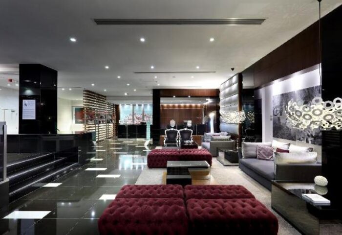 Eurostars Hotel das Letras lobby. Gay-friendly hotel interior with dark floors, modern seating, and stylish decor. Upscale travel destination.