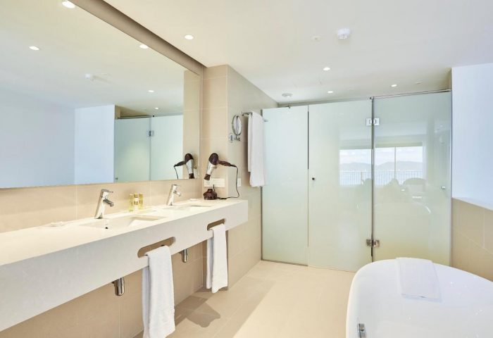 Eurostars Ibiza gay-friendly hotel bathroom. Modern design with double sinks, large mirror, walk-in shower, and bathtub. Ideal for gay travel.
