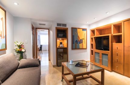 Eurostars Zona Rosa Suites living area. Gay-friendly hotel suite with sofa, TV, kitchenette, and modern decor. Ideal for gay travelers in Mexico City.