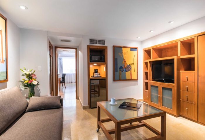 Eurostars Zona Rosa Suites living area. Gay-friendly hotel suite with sofa, TV, kitchenette, and modern decor. Ideal for gay travelers in Mexico City.