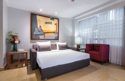 Eurostars Zona Rosa Suites gay-friendly hotel room. Pull-out bed, red chair, and modern art. Perfect for gay travelers in Mexico City.