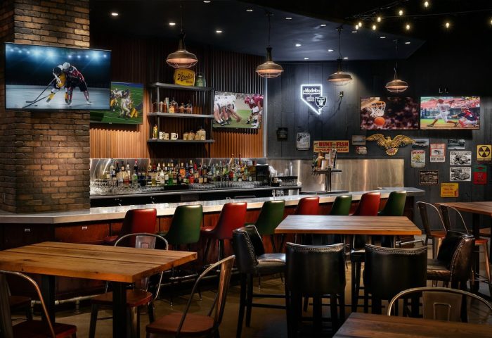 Bar area at the gay-friendly Excalibur Hotel, Las Vegas. TVs showing sports, bar stools, and tables. Great spot for gay men to hang out.
