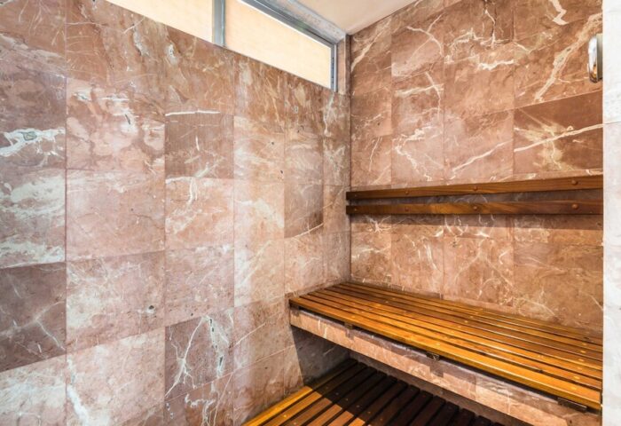 Sauna at Exe Cities Reforma, a gay-friendly hotel. Marble walls and wooden benches offer a relaxing experience in this Mexico City hotel.
