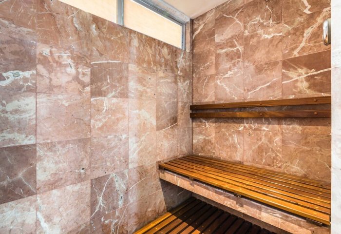 Sauna at Exe Cities Reforma, a gay-friendly hotel. Marble walls and wooden benches offer a relaxing experience in this Mexico City hotel.