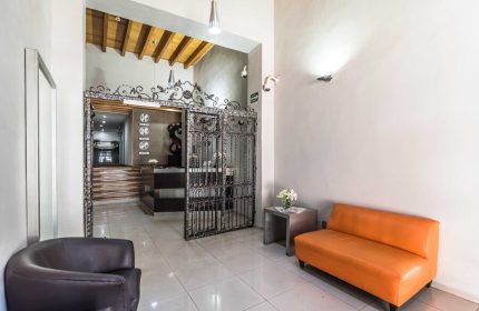 Exe Cities Reforma, a gay-friendly hotel. Hotel lobby with wrought iron gate, reception desk, and seating area. Modern design in Mexico City.
