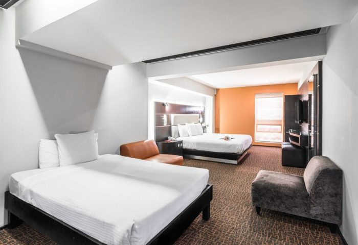 Exe Cities Reforma gay-friendly hotel room. Two beds, seating area, modern decor. Comfortable stay in Mexico City. #gaytravel #hotelroom