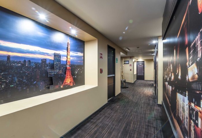 Exe Cities Reforma Hotel hallway. Gay-friendly hotel with city-themed decor. Hallway with Tokyo Tower mural. Modern design.