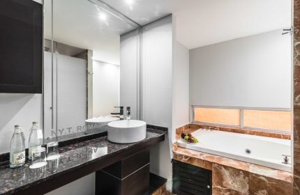 Exe Cities Reforma gay-friendly hotel bathroom. Features a modern sink, large mirror, and a luxurious bathtub with marble accents. Ideal for gay travel.