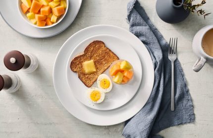 Breakfast at Fairfield by Marriott Montreal Downtown, a gay-friendly hotel. Toast, eggs, fruit, and coffee on a table setting.
