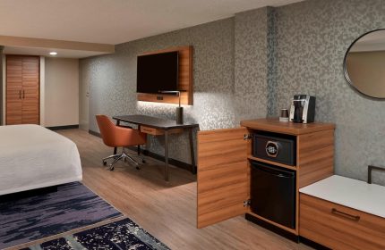 Fairfield by Marriott Montreal Downtown room. Desk, chair, TV, safe, mini-fridge, and coffee maker. Gay-friendly hotel room.