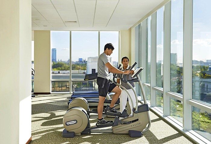 Fairmont Makati: Man exercising with a trainer at the gym. This gay-friendly hotel with restrictions offers fitness amenities for its guests.