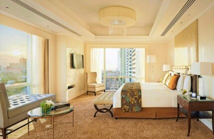 Fairmont Makati hotel room interior. Luxury gay-friendly hotel with city view, king bed, sitting area, and elegant decor. Upscale travel.