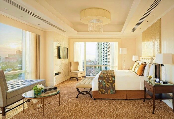 Fairmont Makati hotel room interior. Luxury gay-friendly hotel with city view, king bed, sitting area, and elegant decor. Upscale travel.
