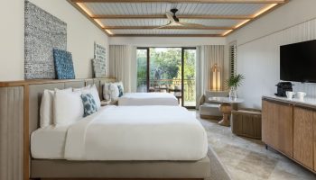 Fairmont Mayakoba's gay-friendly hotel room with two beds, balcony, modern decor, and view. A luxury travel destination for gay men.
