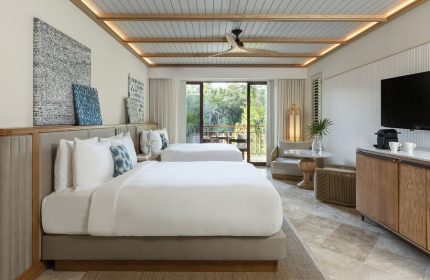 Fairmont Mayakoba's gay-friendly hotel room with two beds, balcony, modern decor, and view. A luxury travel destination for gay men.