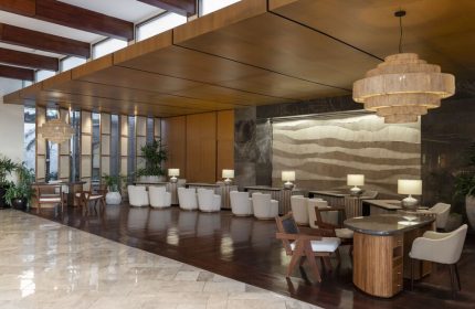 Fairmont Mayakoba, a gay-friendly hotel. Lobby with modern lighting, wood accents, and seating. A stylish choice for gay travelers.