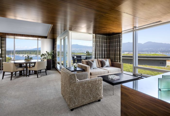 Fairmont Pacific Rim Hotel suite. Gay-friendly hotel with ocean view, dining table, sofa, and chair. Luxury travel for gay men in Vancouver.